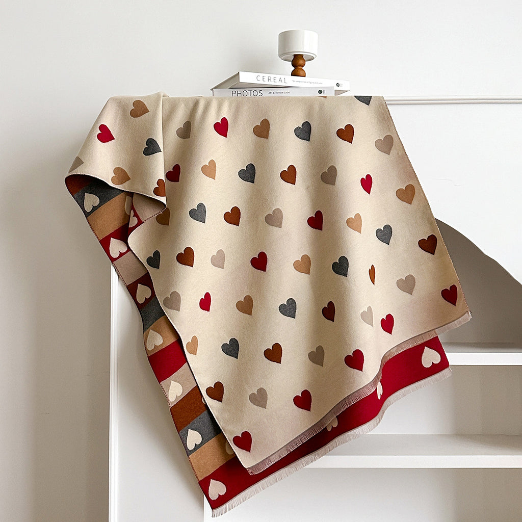 Beige scarf with multicolored heart pattern draped over a white surface