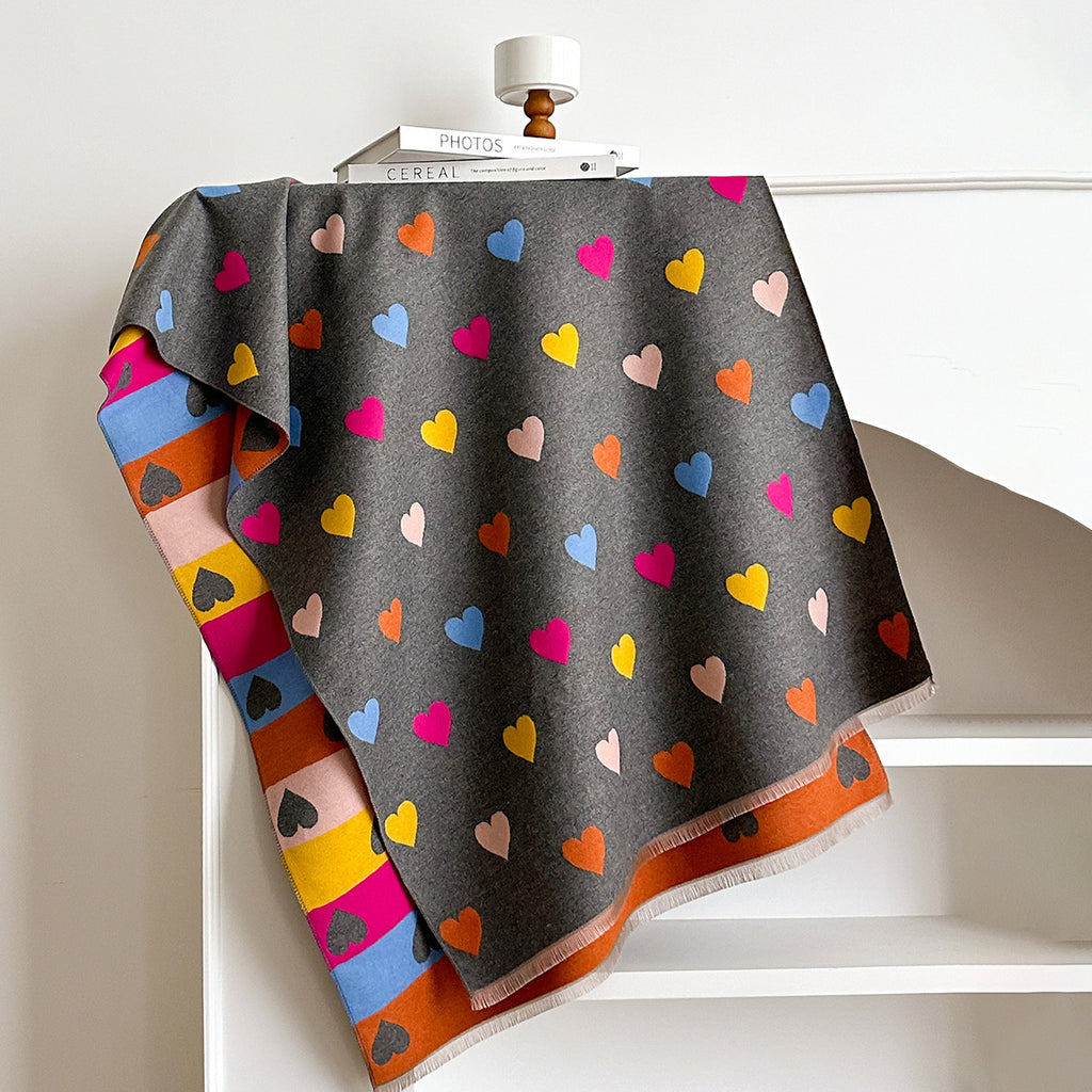 Colorful heart-patterned blanket draped over a white surface