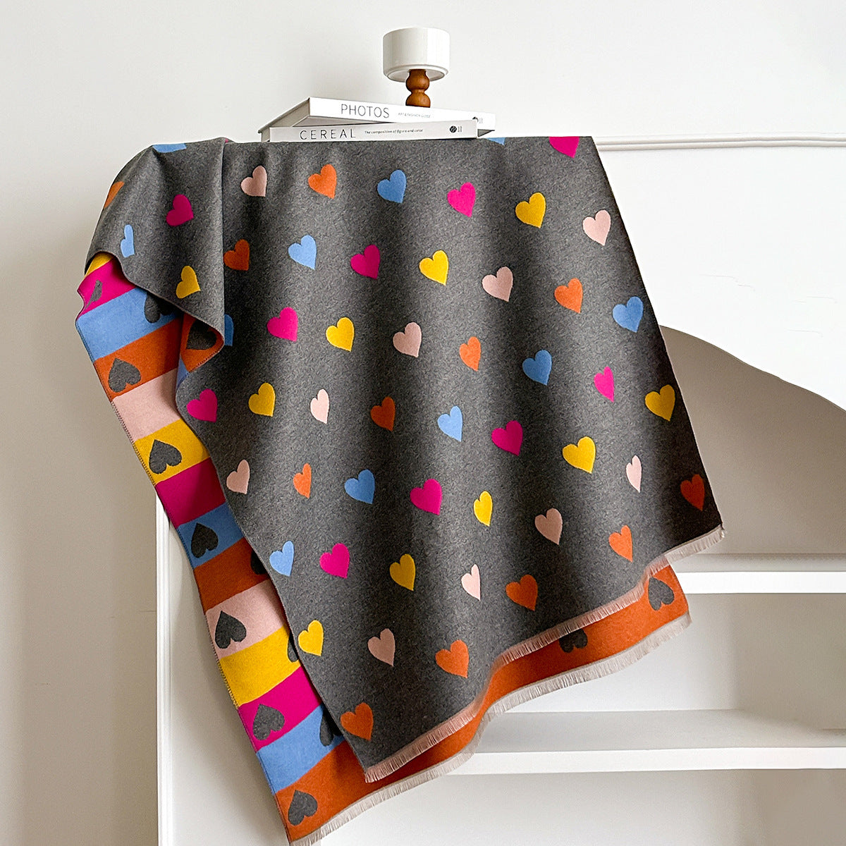 Colorful heart-patterned blanket draped over a white surface