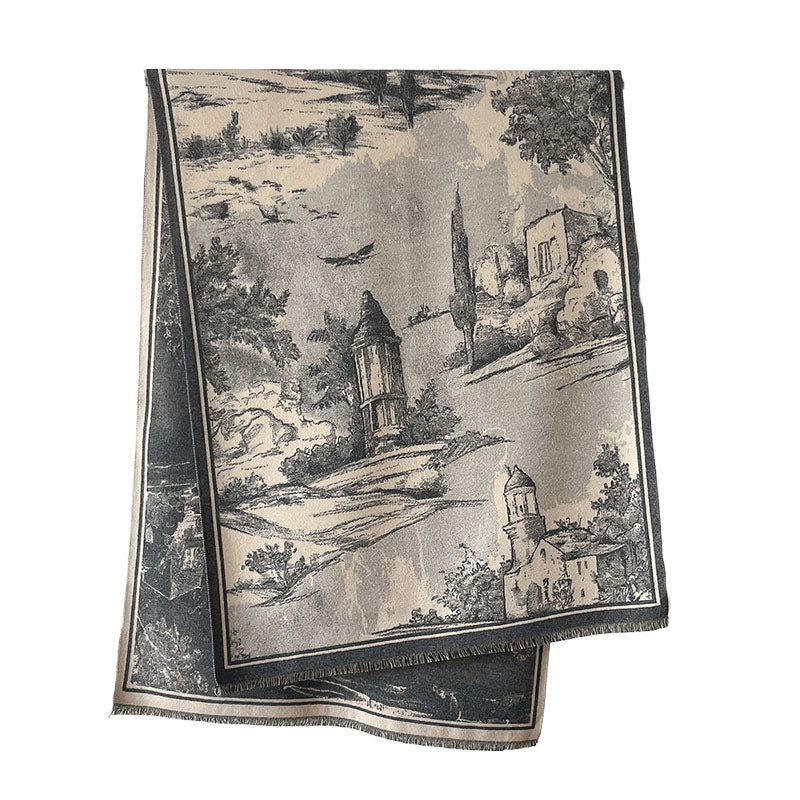 A folded woven textile featuring a scenic landscape print in black, gray, and beige tones, with a fringed edge, photographed on a plain white background.