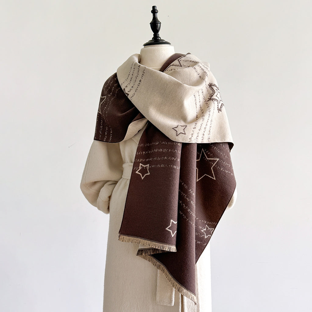 A cream and dark brown patterned scarf with star and script motifs, draped on a cream-colored mannequin against a plain white background.