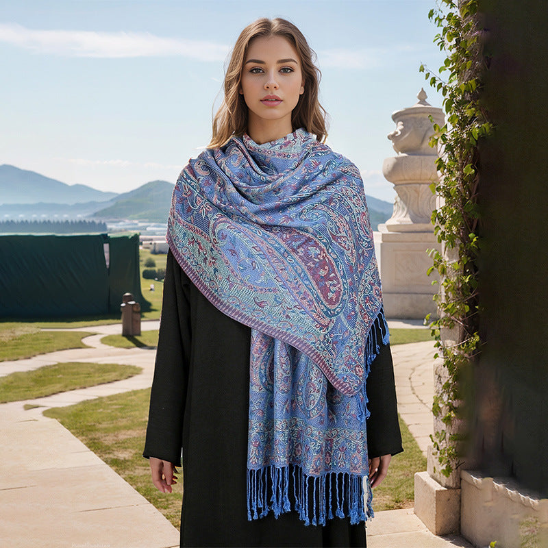 Woman wearing a blue patterned scarf outdoors with mountains in the background