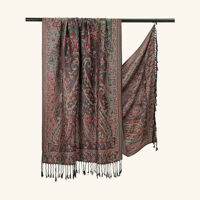 Patterned scarf with fringes on a black rod against a white background