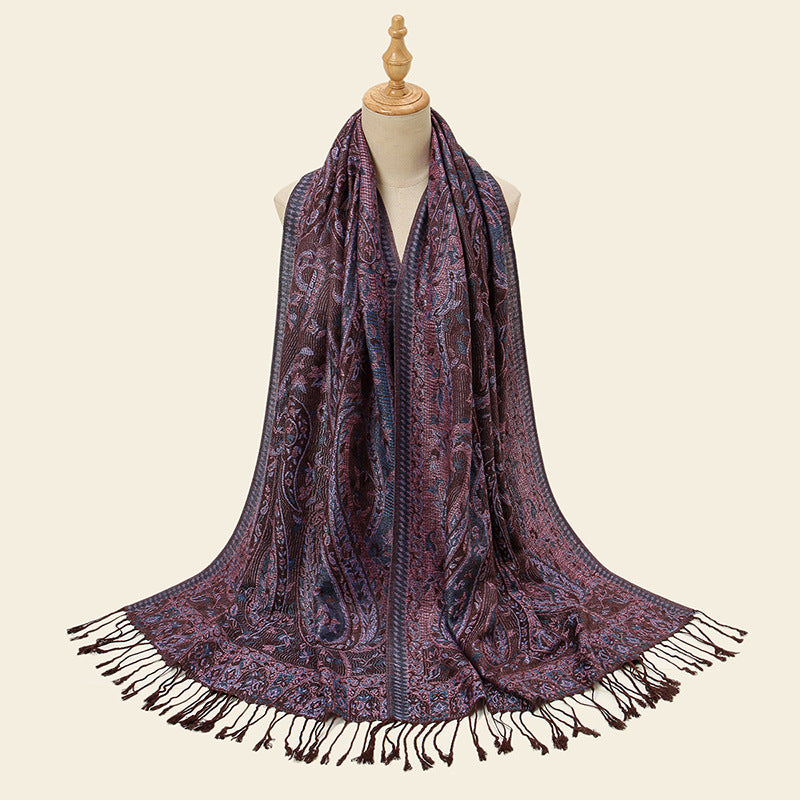 Patterned scarf with fringes on a mannequin against a beige background