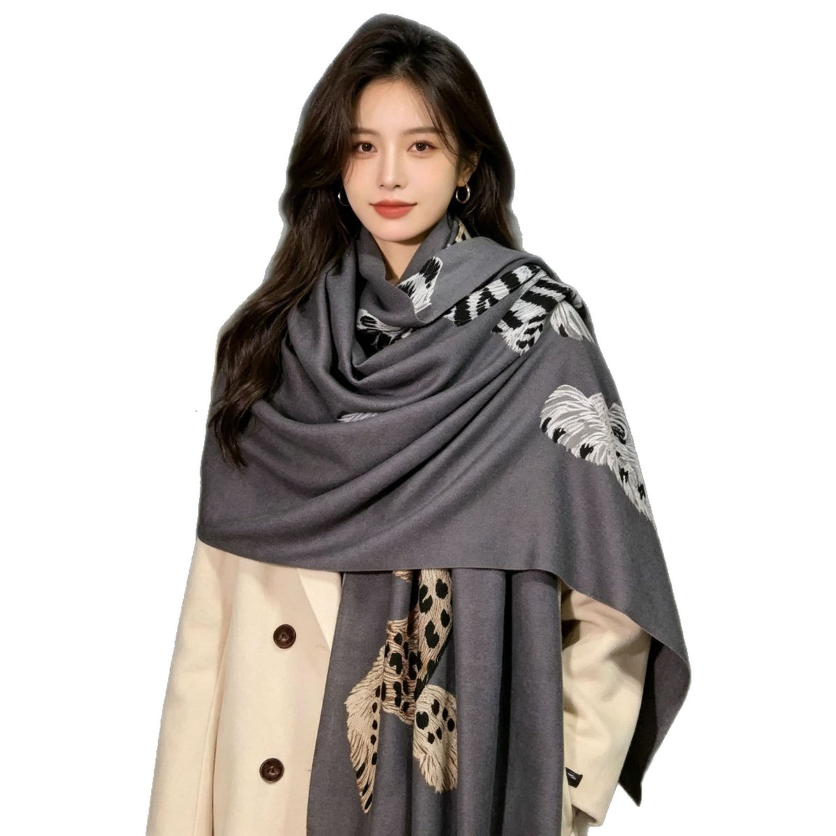 A woman wearing a large charcoal gray shawl with white and beige feather-like patterns, styled over a cream-colored coat against a plain white background.